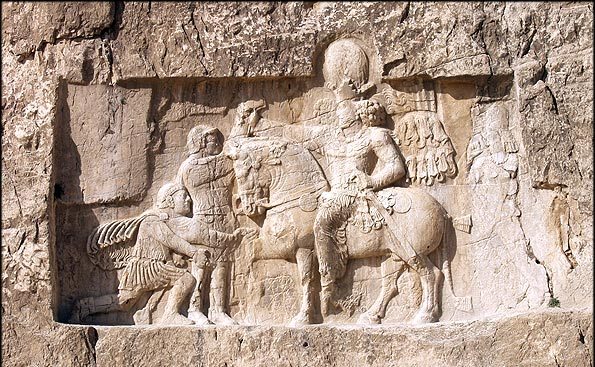 Rock-face relief at Naqsh-e Rustam of Shapur (on horseback) with Philip the Arab and Emperor Valerian.